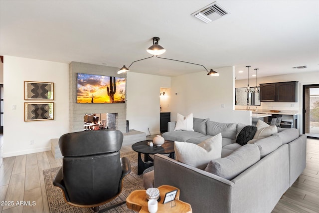 living room with light hardwood / wood-style floors and a multi sided fireplace