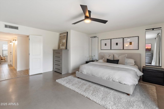 bedroom with ceiling fan and concrete flooring