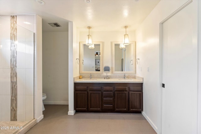 bathroom featuring tile patterned floors, toilet, a shower with door, and vanity