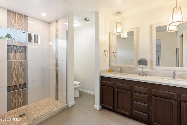 bathroom featuring vanity, toilet, tile patterned floors, and a tile shower