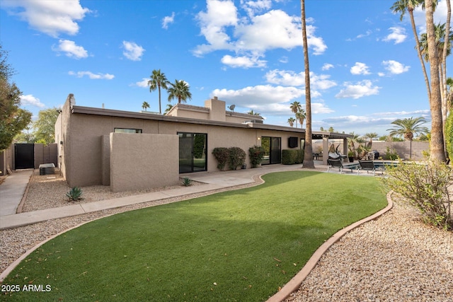 rear view of property featuring a patio area and a lawn