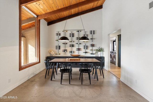 dining room with high vaulted ceiling, wooden ceiling, washer and clothes dryer, and beam ceiling