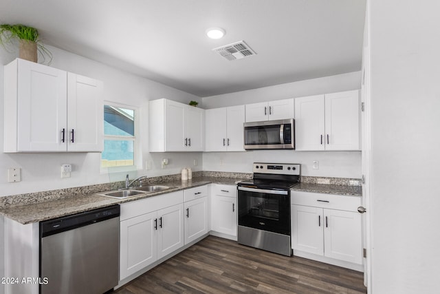 kitchen featuring dark hardwood / wood-style floors, stone countertops, appliances with stainless steel finishes, sink, and white cabinets