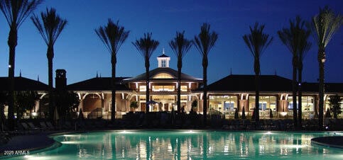 pool at night featuring a community pool