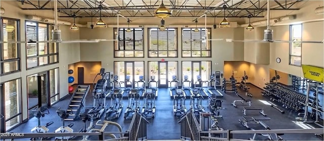 gym with french doors and a towering ceiling