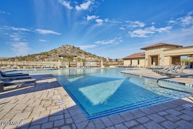 pool with a patio and fence