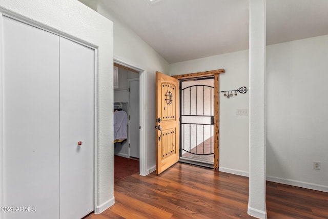 foyer entrance with dark hardwood / wood-style floors and vaulted ceiling