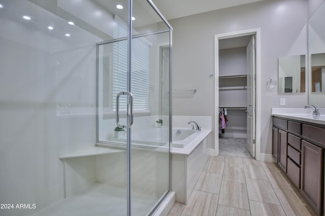 bathroom with vanity and shower with separate bathtub