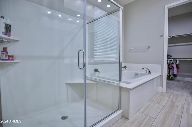 bathroom featuring shower with separate bathtub