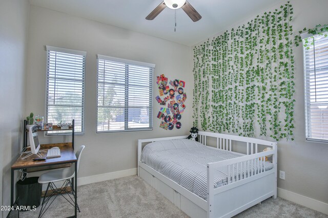 bedroom with light carpet, multiple windows, and ceiling fan