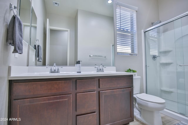 bathroom featuring vanity, toilet, an enclosed shower, and wood-type flooring