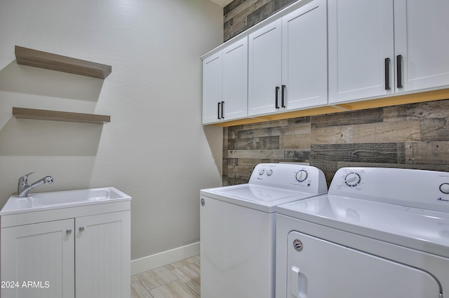 laundry area featuring cabinets, separate washer and dryer, sink, and light tile patterned floors