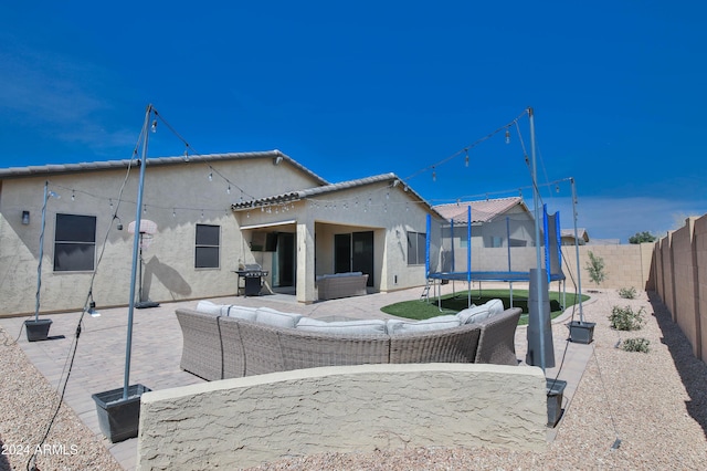 rear view of property with a patio area, an outdoor hangout area, and a trampoline