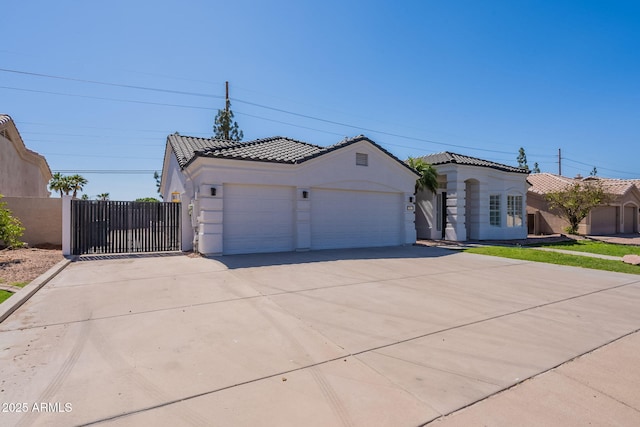 1062 N Robin Ln, Mesa, AZ 85213 - mediterranean / spanish-style house featuring an attached garage, concrete driveway, stucco siding, a tiled roof, and a gate