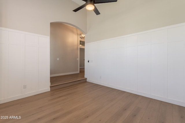 1062 N Robin Ln, Mesa, AZ 85213 - spare room featuring arched walkways, light wood-style floors, ceiling fan, and a decorative wall