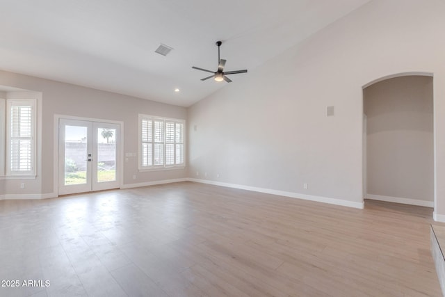 1062 N Robin Ln, Mesa, AZ 85213 - unfurnished living room with arched walkways, ceiling fan, baseboards, light wood-style floors, and high vaulted ceiling