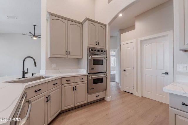 1062 N Robin Ln, Mesa, AZ 85213 - kitchen featuring stainless steel appliances, a sink, a ceiling fan, light wood-type flooring, and light stone countertops