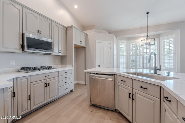 1062 N Robin Ln, Mesa, AZ 85213 - kitchen featuring appliances with stainless steel finishes, a sink, hanging light fixtures, light wood-style flooring, and a chandelier