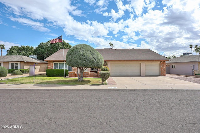 view of front facade featuring a garage, a front yard, brick siding, and driveway