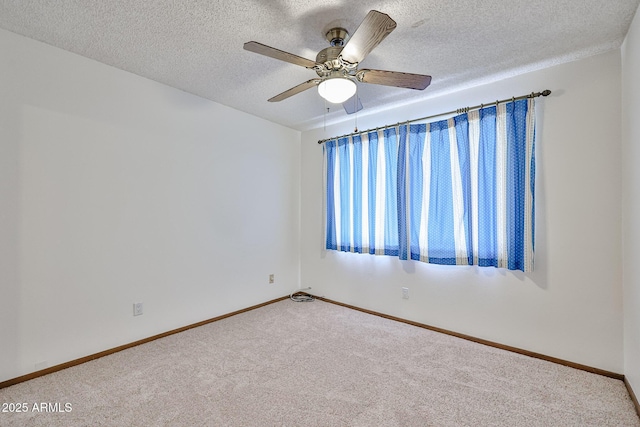 empty room featuring ceiling fan, carpet, baseboards, and a textured ceiling