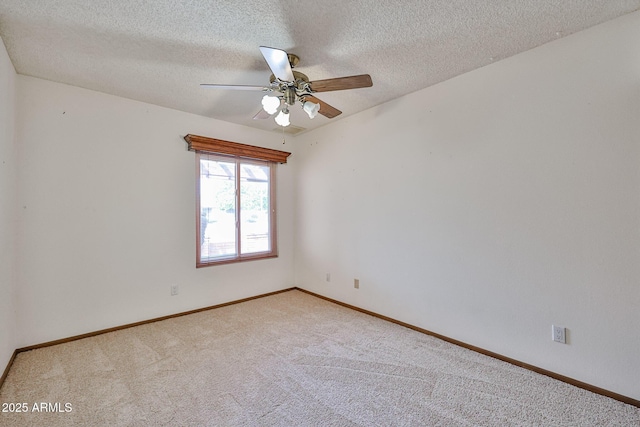 empty room featuring a textured ceiling, carpet flooring, baseboards, and ceiling fan