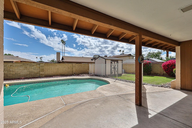 view of pool featuring a patio, a fenced in pool, a fenced backyard, an outdoor structure, and a storage shed