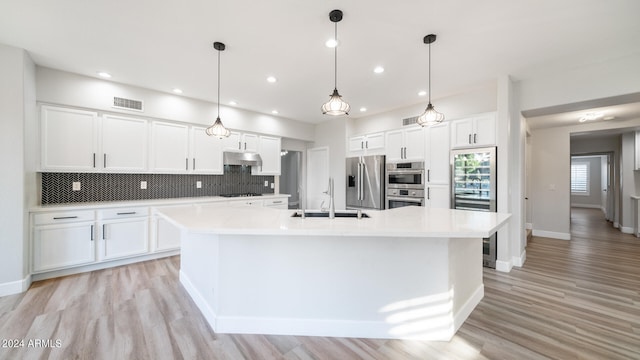 kitchen featuring white cabinets, a large island, sink, and stainless steel appliances