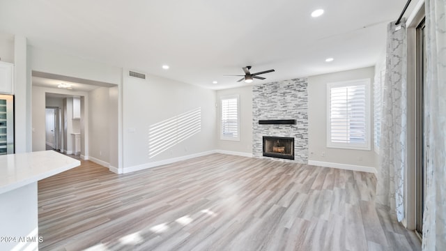 unfurnished living room featuring light hardwood / wood-style floors, ceiling fan, and a healthy amount of sunlight