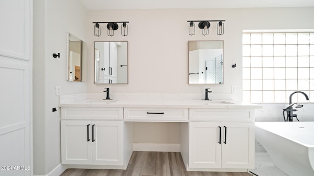 bathroom with plus walk in shower, vanity, and hardwood / wood-style flooring