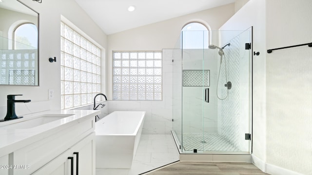 bathroom with a wealth of natural light, plus walk in shower, wood-type flooring, and lofted ceiling