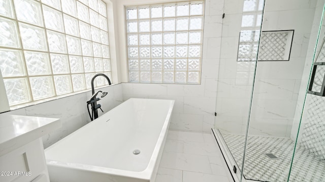 bathroom featuring plenty of natural light, shower with separate bathtub, tile walls, and vanity