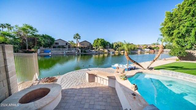 view of pool featuring a patio, a water view, and an outdoor fire pit