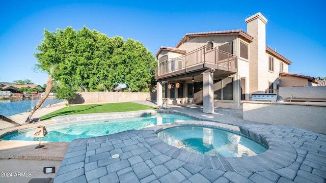 view of pool featuring an in ground hot tub, a water view, and a patio area