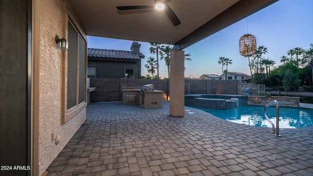 pool at dusk featuring an in ground hot tub, a patio, ceiling fan, and grilling area