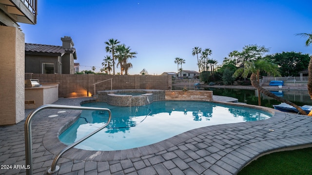 view of swimming pool with an in ground hot tub