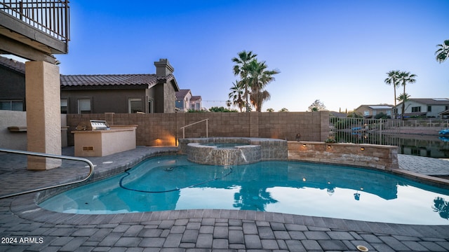 view of pool featuring exterior kitchen and an in ground hot tub