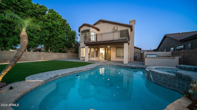 back of property featuring a pool with hot tub, a balcony, a yard, area for grilling, and a patio