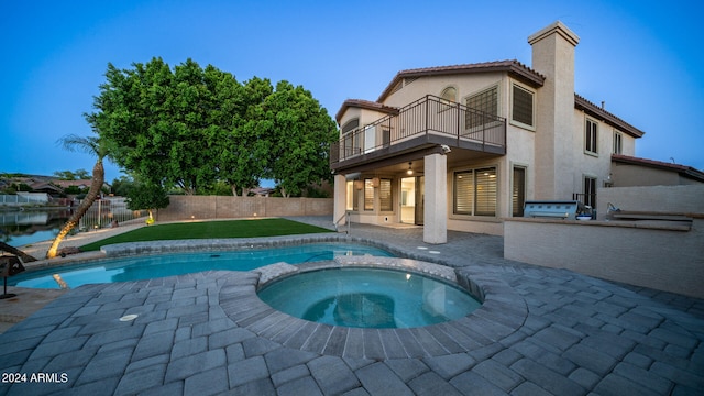 view of pool featuring exterior kitchen, an in ground hot tub, and a patio