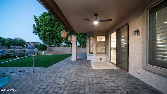 view of patio featuring a water view and ceiling fan