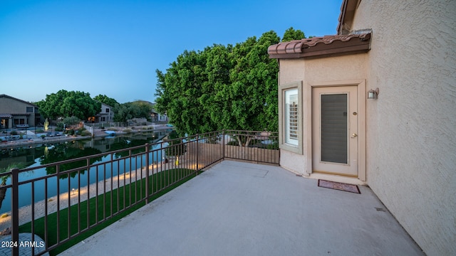 view of patio featuring a balcony and a water view