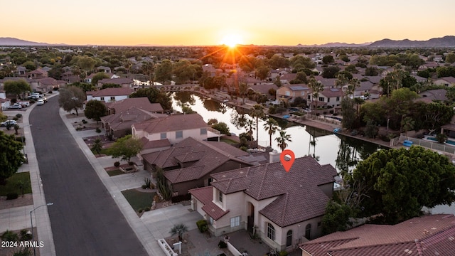 aerial view at dusk featuring a water view