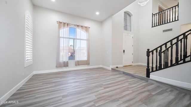 foyer with a towering ceiling and light hardwood / wood-style floors