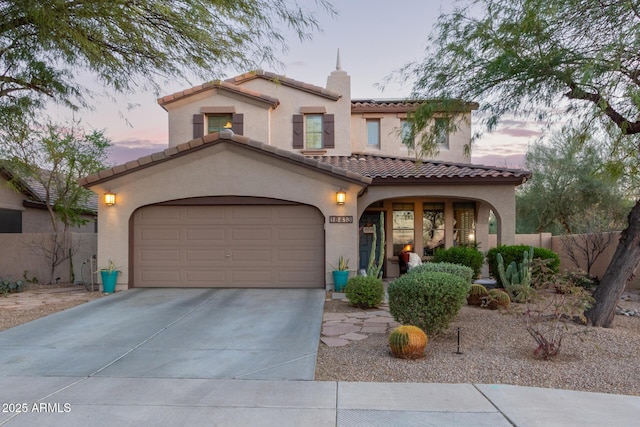 mediterranean / spanish-style house with driveway, a garage, solar panels, a chimney, and stucco siding