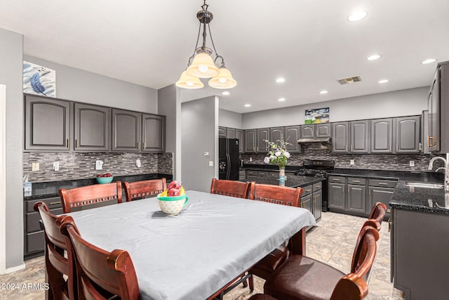 kitchen featuring a center island, black fridge with ice dispenser, decorative backsplash, and range with gas cooktop