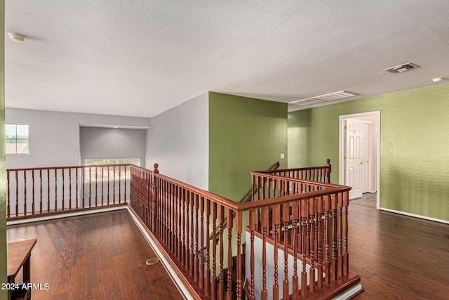 hallway featuring dark hardwood / wood-style flooring and a textured ceiling