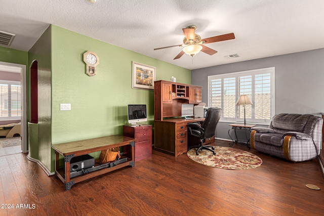 home office with ceiling fan, dark hardwood / wood-style flooring, and a textured ceiling