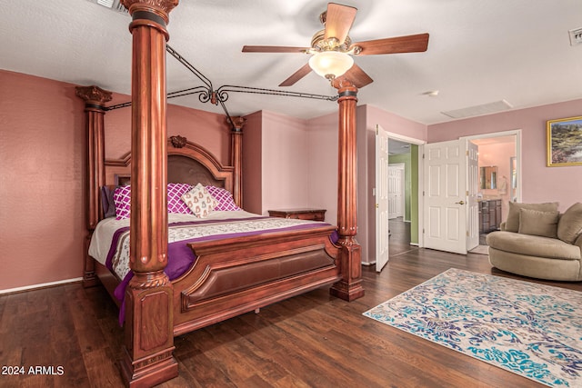 bedroom with a textured ceiling, dark wood-type flooring, connected bathroom, and ceiling fan