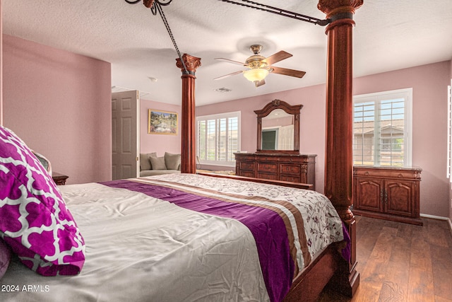 bedroom featuring multiple windows, a textured ceiling, ceiling fan, and dark hardwood / wood-style floors