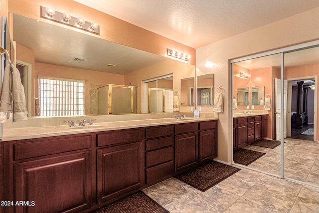 bathroom with a shower with shower door, a textured ceiling, and vanity