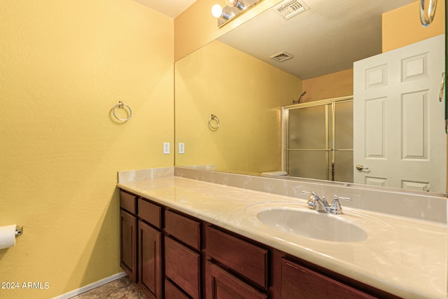 bathroom featuring vanity and a shower with shower door